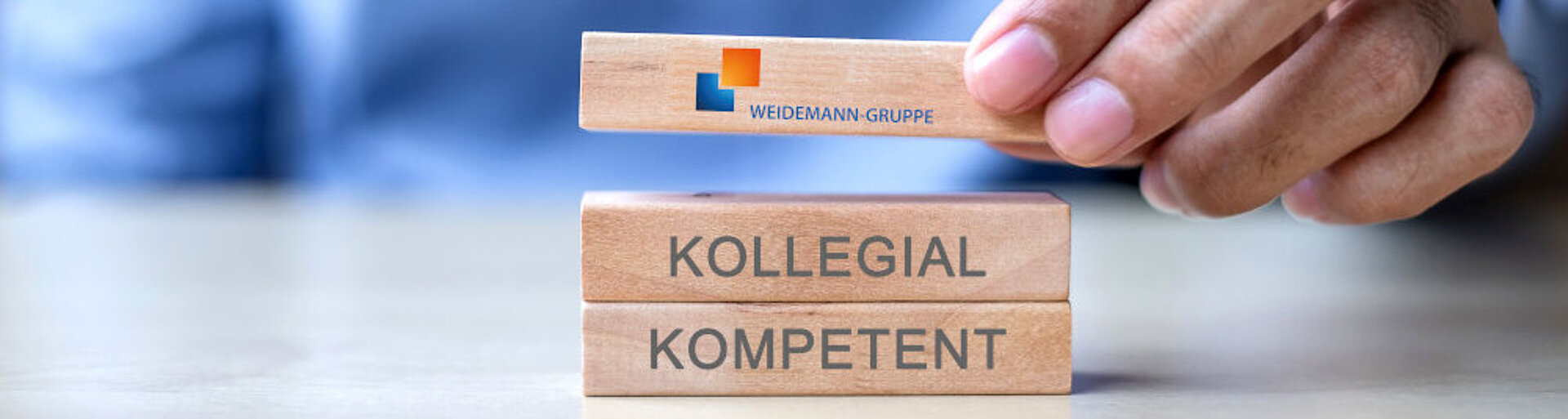 Mission statement: 3 building blocks are stacked on top of each other. Below "competent", above "collegial" and above that the logo of the Weidemann Group