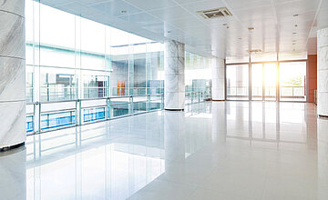 Gebäudemanagement: Bild zeigt ein modernes Bürogebäude von innen . Der Boden glänzt.