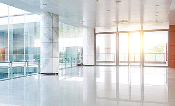 Gebäudemanagement: Bild zeigt ein modernes Bürogebäude von innen. Der Boden glänzt.